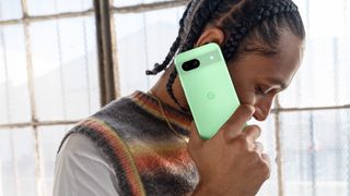 Man holding Google Pixel 8a with aloe