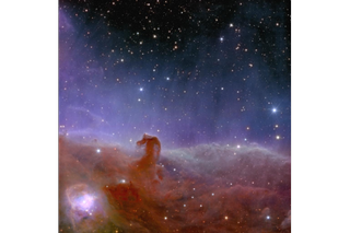 At the bottom of the screen, a very hazy looking reddish gas gathers to create a small hook shape on the left.  Above is a glow of purple light gradually fading across the top of the image, showing a dark region of space with star spots.