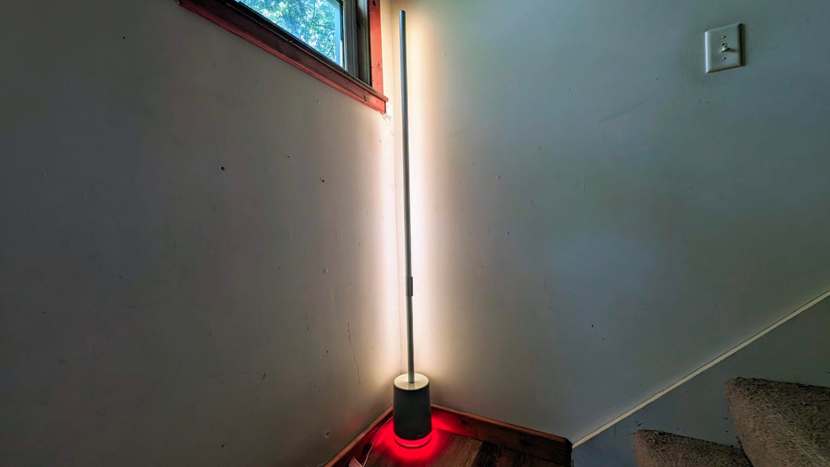 Govee Floor Lamp Pro in a corner, with the main light in white and the base in red.