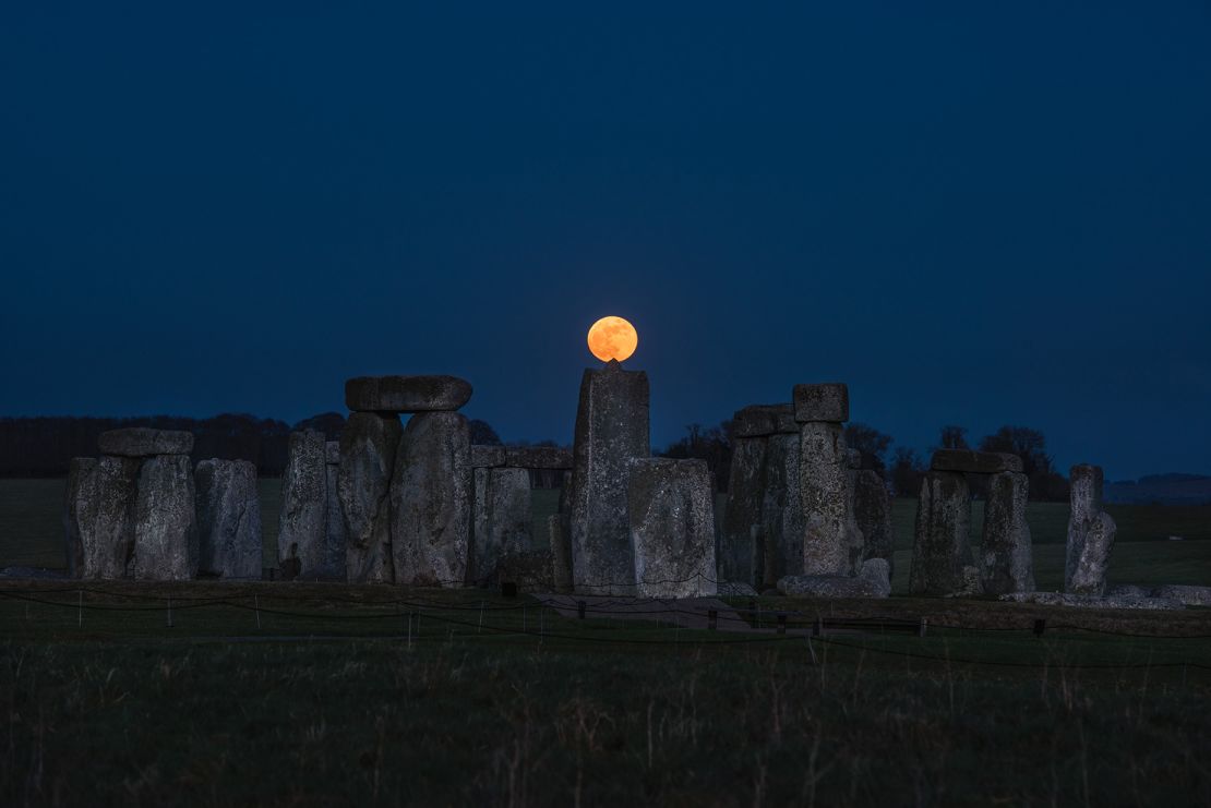 The moon is seen above the megaliths that make up Stonehenge, located on Salisbury Plain in Wiltshire, England.