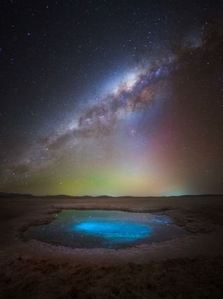 The Milky Way photographed over a bright blue pool in the Atacama Desert, Chile