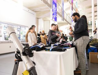 a man stands behind a table and hands out gifts to children