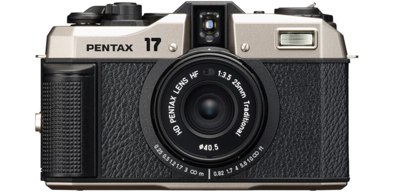 Front view of a Pentax camera with a 25mm f/3.5 lens.  The camera features a silver top, a black textured body, and various control dials and buttons. "Pentax" and "17" are indicated at the top along with the lens specifications around the lens barrel.