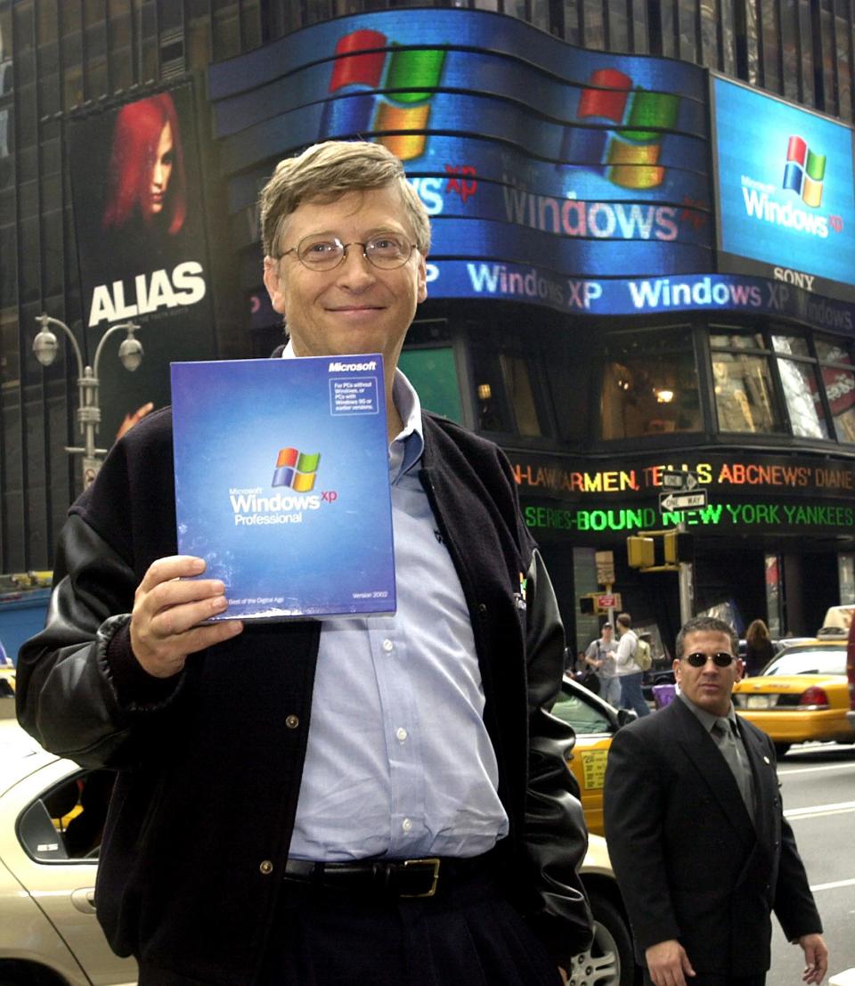 (FILES) This photo shows Microsoft Chairman Bill Gates holding a copy of the new Windows XP operating system as he poses for photos in New York's Times Square during the launch of Windows XP on October 25, 2001 in New York.  Microsoft and the US Department of Justice have agreed to a settlement framework in the government's marathon antitrust case against the software giant, with a federal judge ordering negotiations to end by November 2, 2001. AFP PHOTO HENNY RAY ABRAMS (Photo by HENNY RAY ABRAMS / AFP) (Photo by HENNY RAY ABRAMS/AFP via Getty Images)