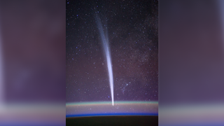 a bright fuzzy band can be seen oriented from top to bottom in a photo of the starry night sky